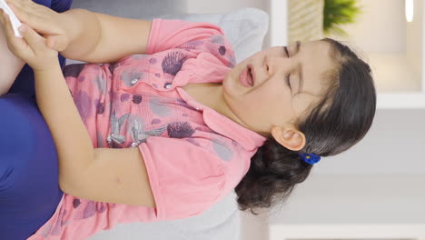 Vertical-video-of-Girl-child-covering-his-mouth-and-nose-with-a-tissue-while-sneezing.